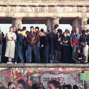 West Berlin citizens hold a vigil atop the Berlin Wall in front of the Brandenburg Gate on November 10, 1989, the day after the East German government opened the border between East and West Berlin.