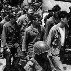 In this undated photo from North Korea’s official Korean Central News Agency, American combatants captured during the Korean War march down a street.