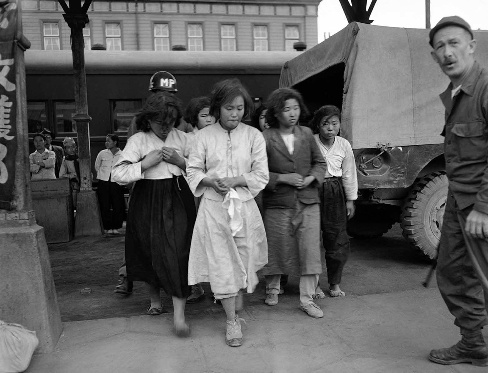 Captured by American forces in the Taegu area of South Korea on October 8, 1950, these North Korean girls are marched to a train which will take them to a prisoner of war camp at Pusan.