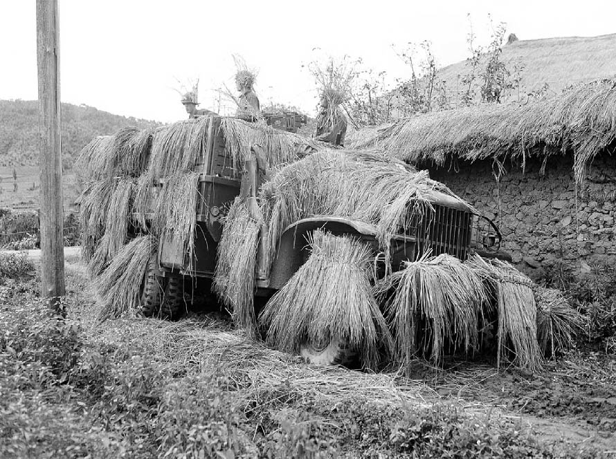A command post somewhere in South Korea on July 12, 1950, as American soldiers keep on the alert with their straw covered camouflaged weapons carrier.