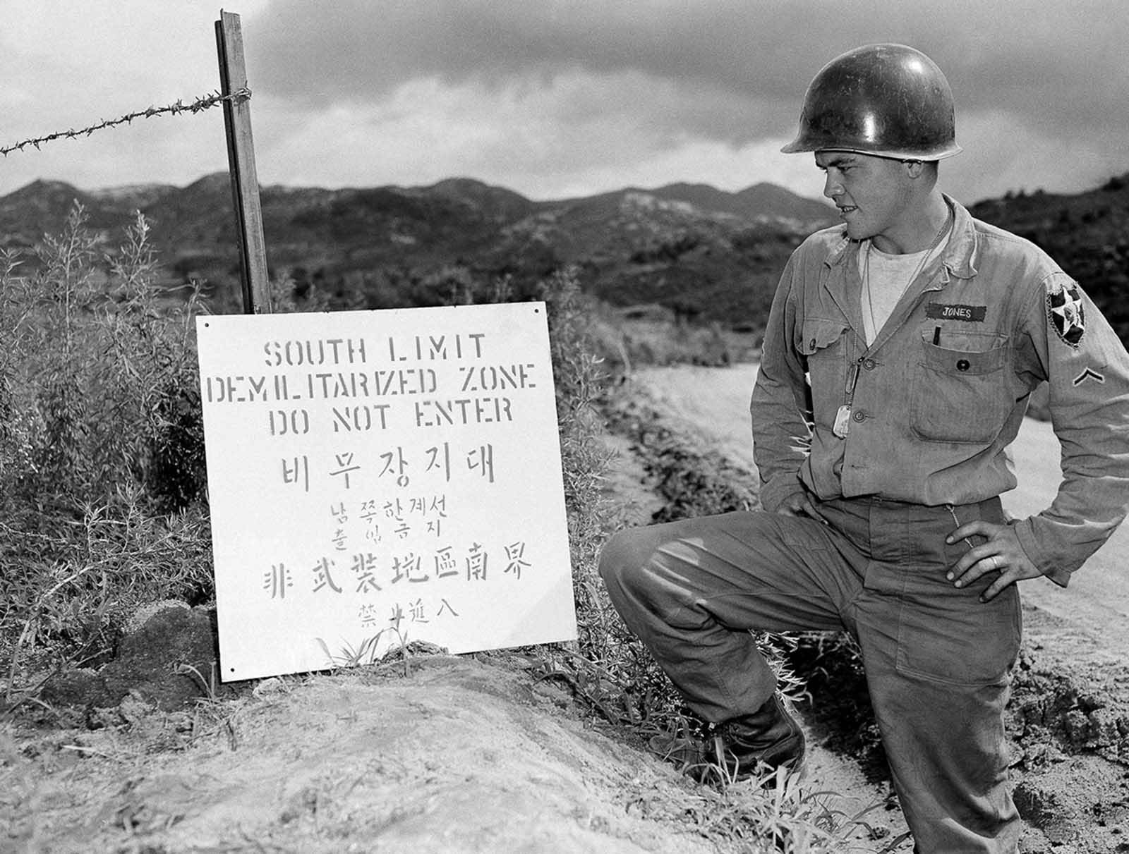 PFC Donald Jones of Topeka, Kansas, pauses to read a sign just posted on the south limit of the demilitarized zone in Korea on July 30, 1953.