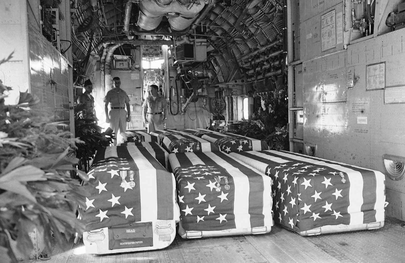 Flag-draped coffins of eight American Servicemen killed in attacks on U.S. military installations in South Vietnam, on February 7, are placed in transport plane at Saigon, February 9, 1965, for return flight to the United States. Funeral services were held at the Saigon Airport with U.S. Ambassador Maxwell D. Taylor and Vietnamese officials attending.